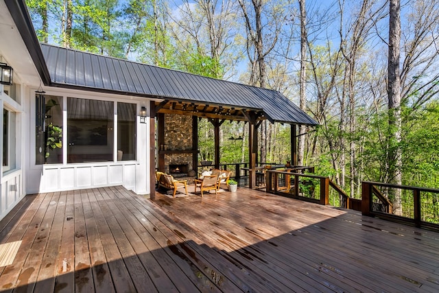 wooden terrace with an outdoor living space with a fireplace