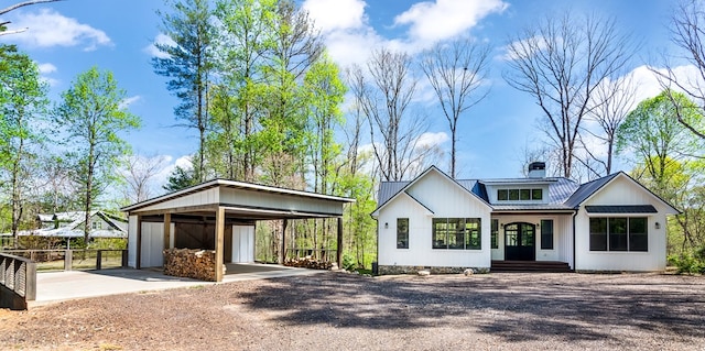 modern inspired farmhouse featuring fence, driveway, metal roof, and a detached carport