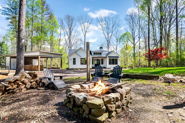 rear view of property with an outdoor fire pit