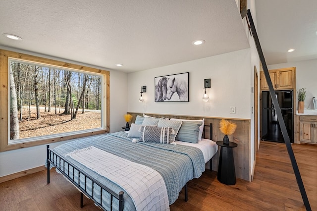366 Three Oaks Dr, Morganton, GA 30559 - bedroom with freestanding refrigerator, a textured ceiling, recessed lighting, wood finished floors, and a wainscoted wall