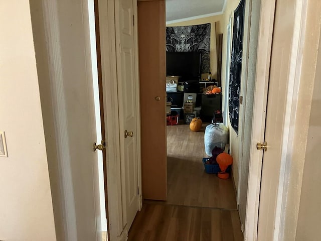 hallway with ornamental molding and hardwood / wood-style flooring