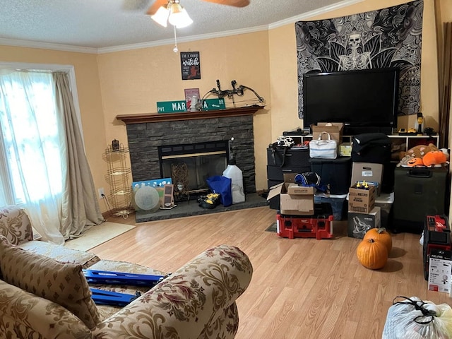 living room with hardwood / wood-style flooring, crown molding, a fireplace, and a textured ceiling