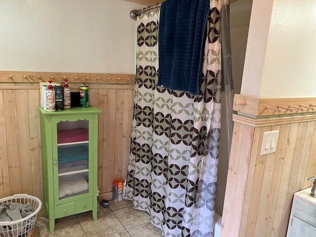 bathroom featuring tile patterned flooring and wood walls