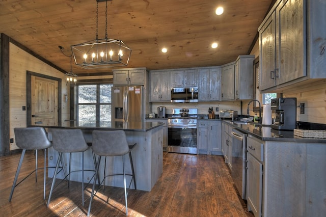 kitchen with appliances with stainless steel finishes, a kitchen island, wooden ceiling, and sink