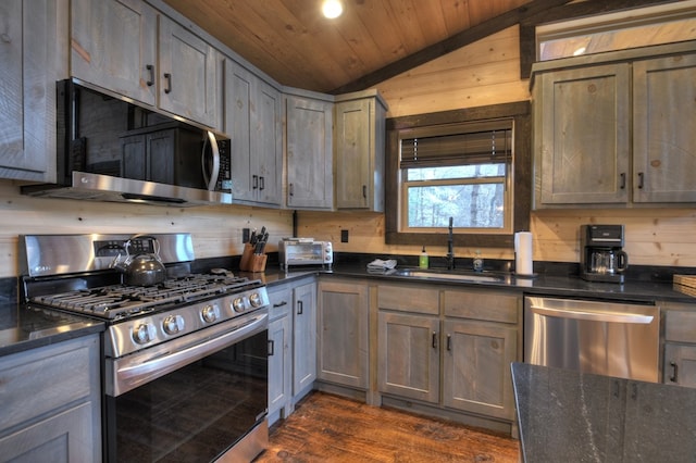 kitchen featuring dark hardwood / wood-style flooring, wood ceiling, stainless steel appliances, vaulted ceiling, and sink