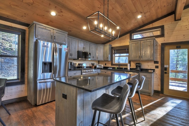 kitchen with decorative light fixtures, a kitchen island, wood ceiling, and stainless steel appliances