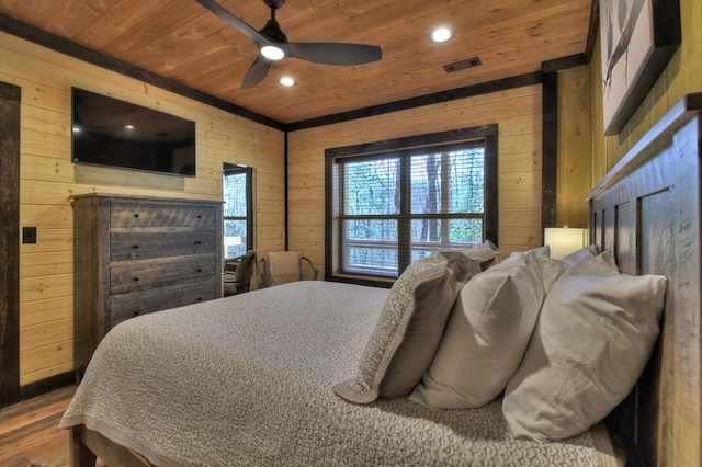 bedroom featuring wood-type flooring, wooden ceiling, ceiling fan, and wooden walls