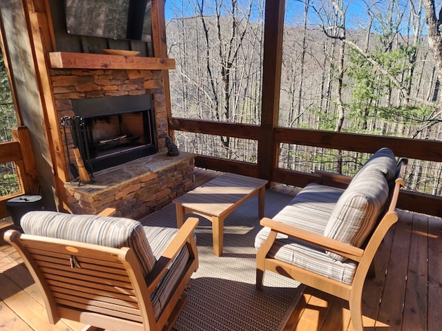 wooden terrace with an outdoor stone fireplace