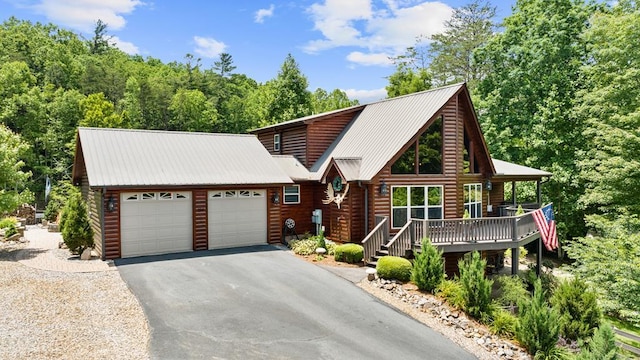 log-style house with covered porch and a garage