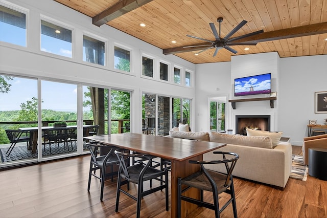 897 Faraday Dr, Ellijay, GA 30540 - dining area with a wood ceiling with exposed beams, a ceiling fan, a towering ceiling, wood finished floors, and a large fireplace