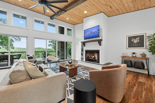 897 Faraday Dr, Ellijay, GA 30540 - living area with a wooden ceiling with exposed beams, a high ceiling, a large fireplace, a ceiling fan, and healthy amount of natural light