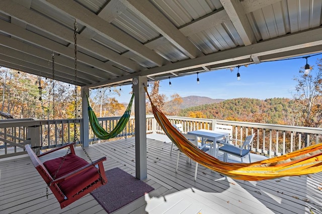 wooden deck with a forest view and a mountain view