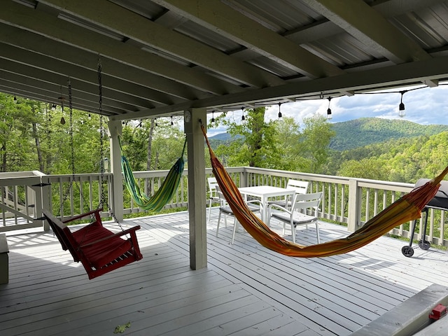 wooden terrace with a wooded view and a mountain view