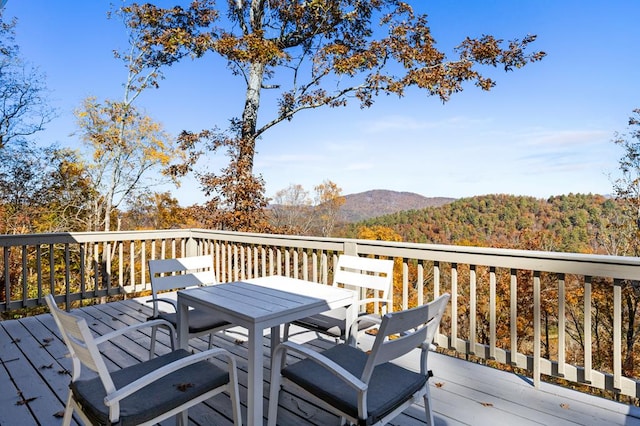 wooden deck featuring a mountain view and outdoor dining space
