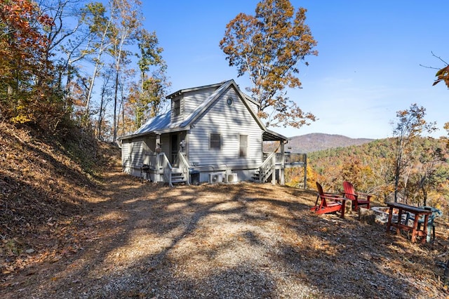 rear view of property with a fire pit and a mountain view