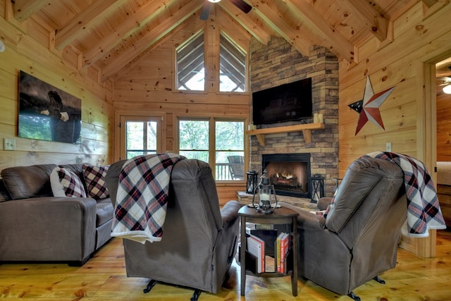 living room featuring beam ceiling, wooden walls, a fireplace, and wood ceiling