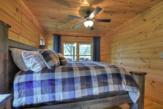 bedroom with wood walls, ceiling fan, and wooden ceiling