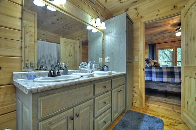 bathroom featuring hardwood / wood-style floors, vanity, wooden ceiling, and wooden walls