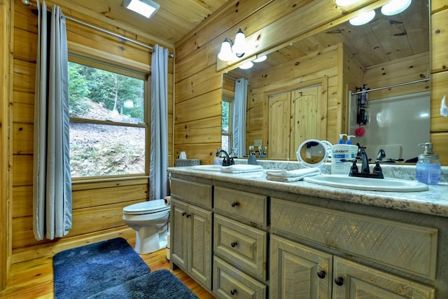 bathroom featuring toilet, plenty of natural light, wooden walls, and wood ceiling