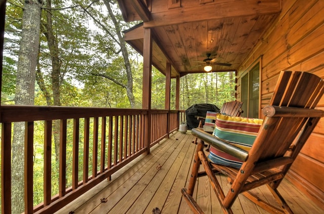 wooden terrace featuring ceiling fan and grilling area