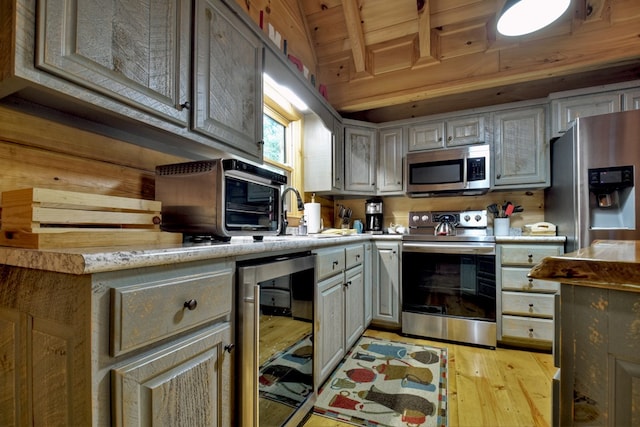 kitchen with wine cooler, appliances with stainless steel finishes, beamed ceiling, light hardwood / wood-style floors, and wood ceiling