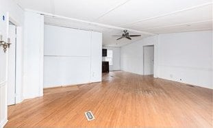 unfurnished living room featuring lofted ceiling, a fireplace, ceiling fan, and wood finished floors