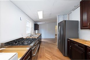 kitchen with dark brown cabinetry, stainless steel appliances, and light countertops