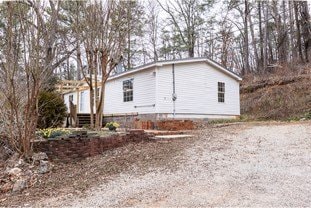 view of side of home featuring gravel driveway