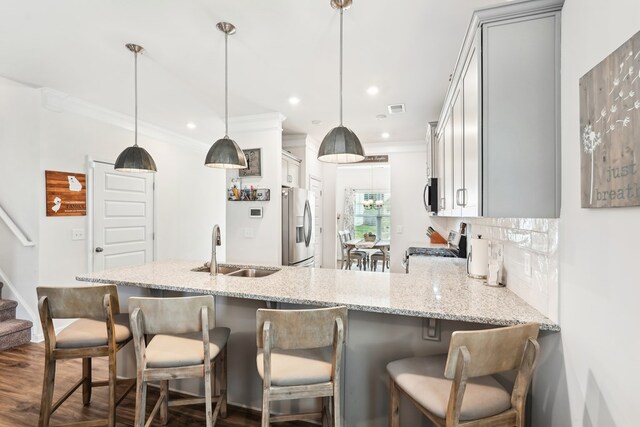 kitchen with crown molding, a sink, gray cabinets, and appliances with stainless steel finishes