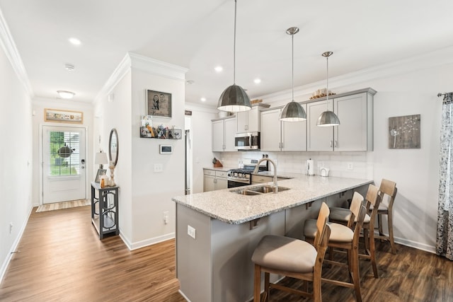 kitchen featuring ornamental molding, baseboards, a kitchen bar, tasteful backsplash, and appliances with stainless steel finishes