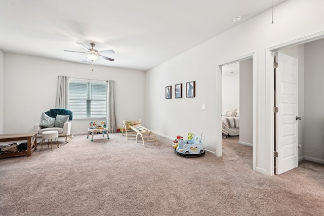 game room with carpet floors, a ceiling fan, and baseboards