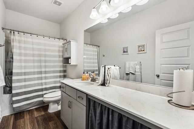 bathroom featuring toilet, visible vents, wood finished floors, and vanity
