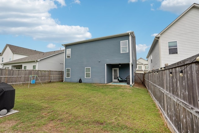 back of house featuring a lawn, a patio, and a fenced backyard
