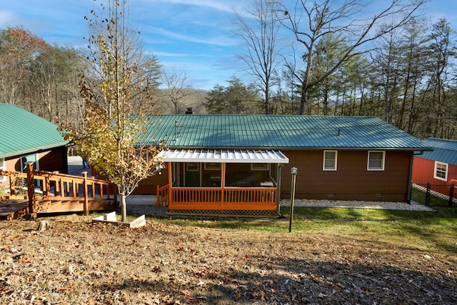 back of property with a sunroom and a wooden deck