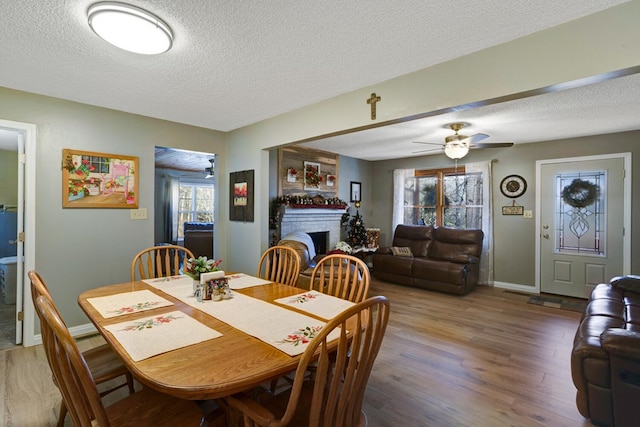 dining space featuring a wealth of natural light, ceiling fan, a textured ceiling, and hardwood / wood-style flooring