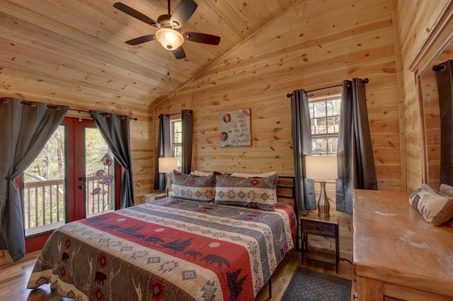 bedroom featuring wood-type flooring, multiple windows, and wooden walls