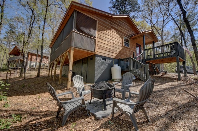 back of house with a deck and an outdoor fire pit