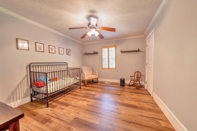 365 Quarles Ln, Ellijay, GA 30540 - bedroom with a textured ceiling, wood finished floors, ornamental molding, a ceiling fan, and a crib