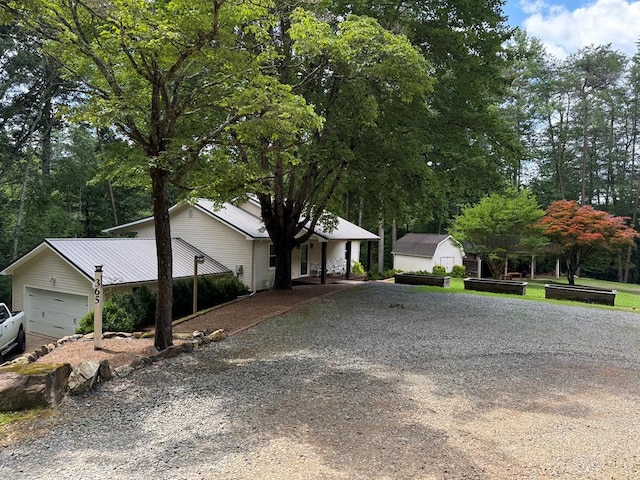 365 Quarles Ln, Ellijay, GA 30540 - ranch-style house with gravel driveway, a storage shed, an attached garage, and view of scattered trees