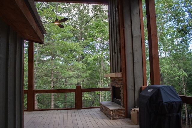 deck with ceiling fan, area for grilling, and a fireplace