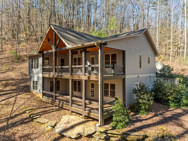 exterior space featuring a shingled roof and a balcony