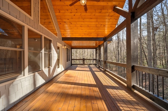 unfurnished sunroom with lofted ceiling with beams, wood ceiling, and ceiling fan