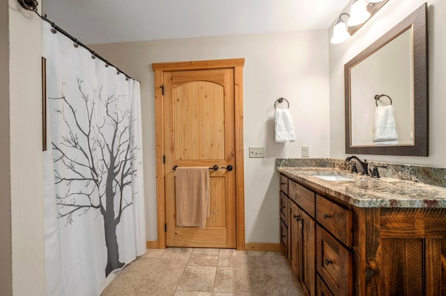 full bathroom featuring baseboards and vanity