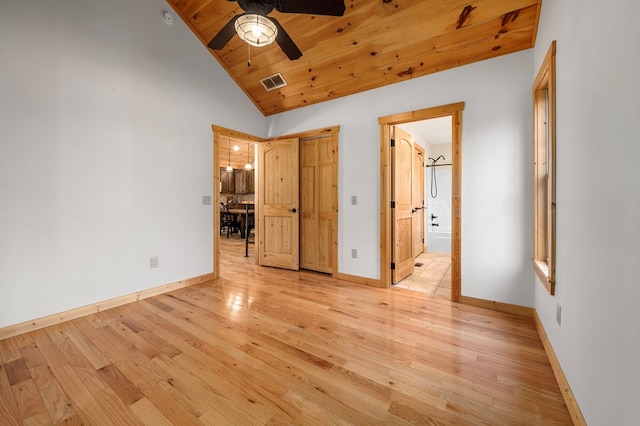 unfurnished bedroom featuring light wood finished floors, visible vents, baseboards, wood ceiling, and high vaulted ceiling