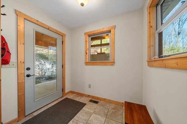 doorway to outside with visible vents, a wealth of natural light, and baseboards