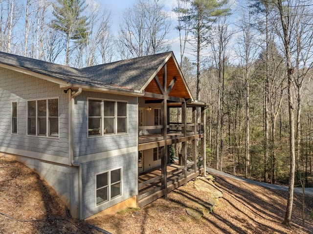 view of side of home featuring roof with shingles