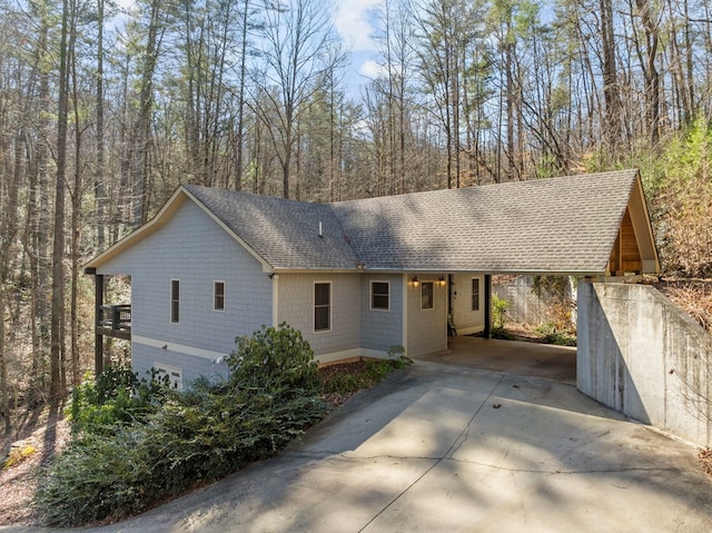 single story home featuring concrete driveway and roof with shingles