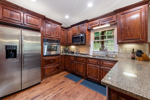 615 Navaho Way, Ellijay, GA 30540 - kitchen with stainless steel appliances, a sink, light wood-type flooring, tasteful backsplash, and dark stone countertops