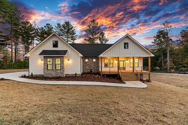 modern farmhouse style home with a yard and covered porch