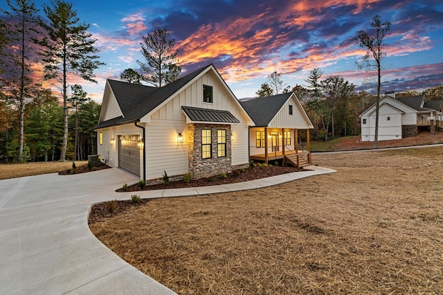 view of front of house with central air condition unit, covered porch, and a garage